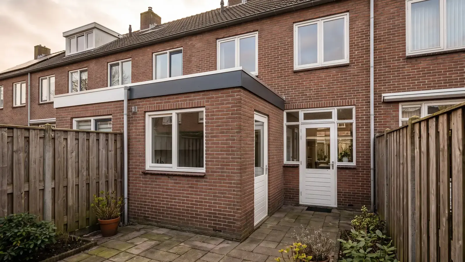 Woning met een plat bitumen dak op een aanbouw