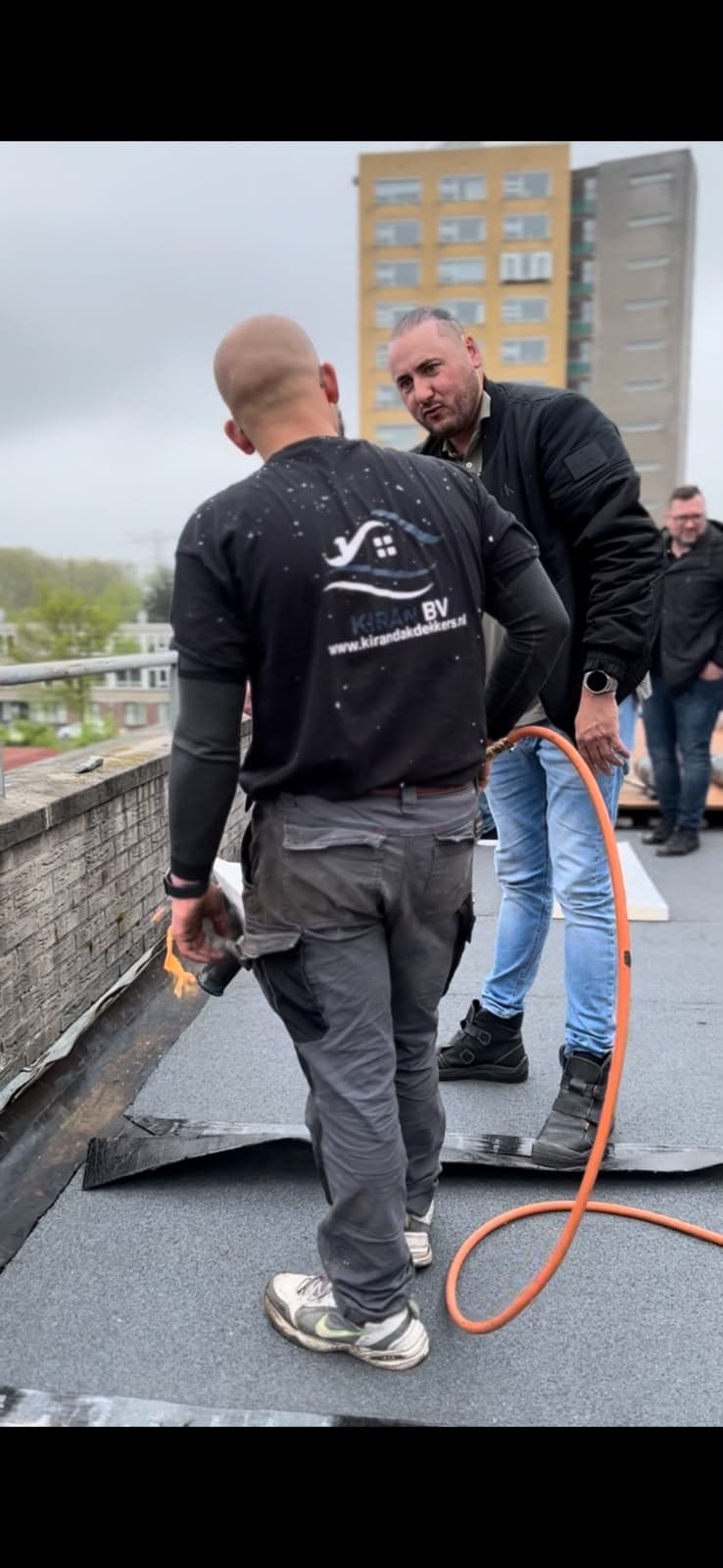 Dakdekker aan het werk op een dak in Ridderkerk — Kiran BV